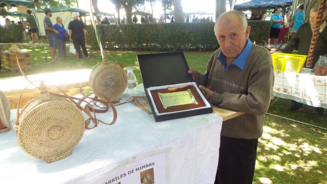 El artesano, Isidro García, recibe una placa por su fidelidad con la feria de Val de San Lorenzo (S. G.)